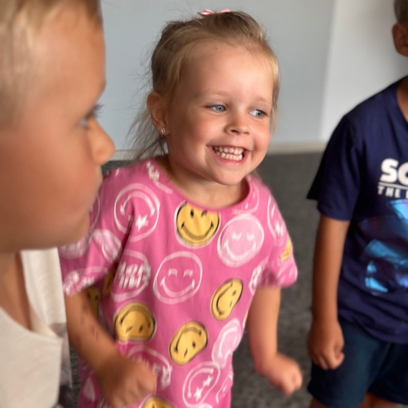 Šypsanti mergaitė jogos užsiėmimo metu